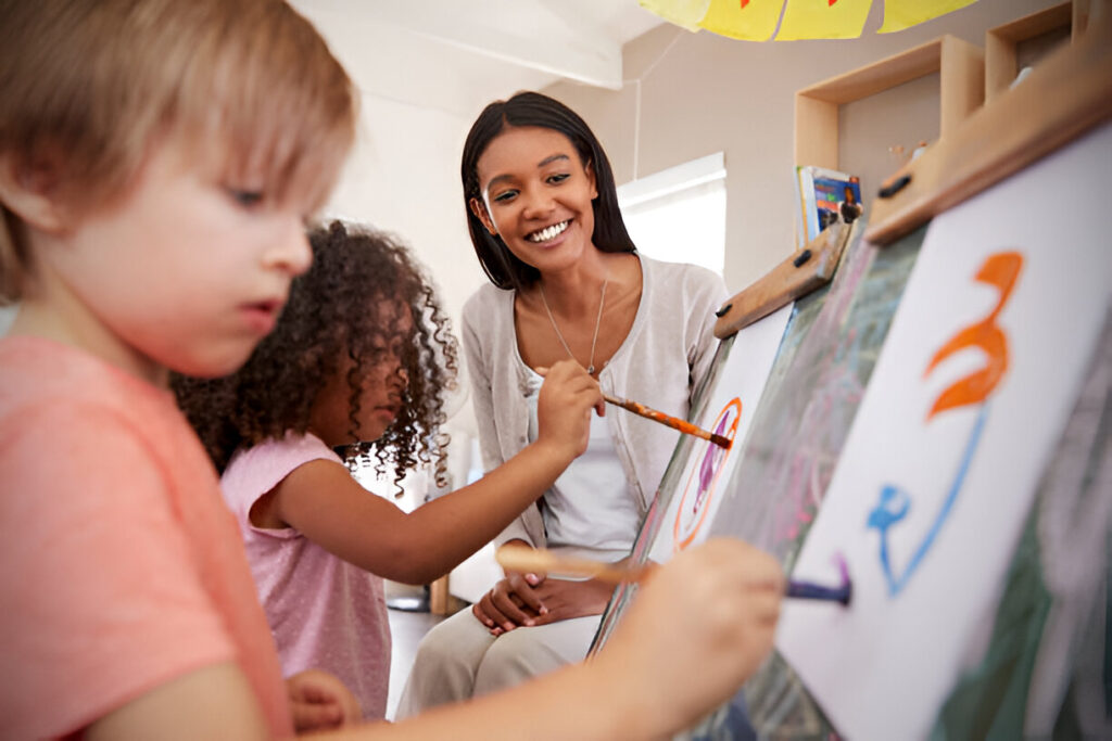 Experienced art teacher guiding diverse students during an art teacher jobs classroom activity, illustrating the career.